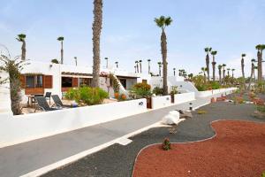 una casa con delle palme davanti di Puerto Chico M a Playa Blanca