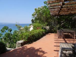 a patio with a table and chairs and the ocean at Holiday Home Waterfront Omis in Omiš