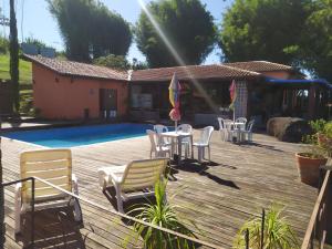 a deck with chairs and a table next to a pool at Recanto Cravo e Canela in Itatiaia +9 photos