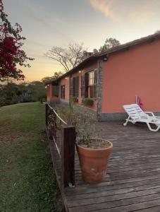 a porch of a house with a potted plant on it at Recanto Cravo e Canela in Itatiaia