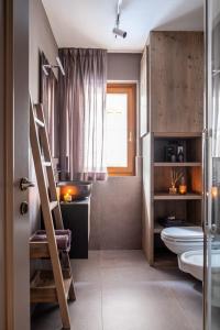 a bathroom with a toilet and a sink and a ladder at Suite Mia in Falcade