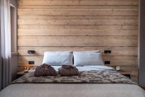a bedroom with a large bed with a wooden wall at Suite Mia in Falcade