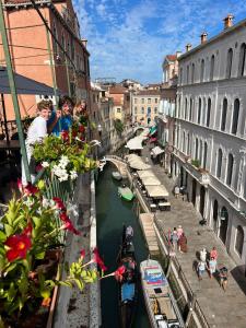 a group of people standing on a balcony looking at a canal at Residenza de l'Osmarin Suites in Venice