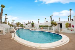a swimming pool in a resort with palm trees at Puerto Chico 9 in Playa Blanca