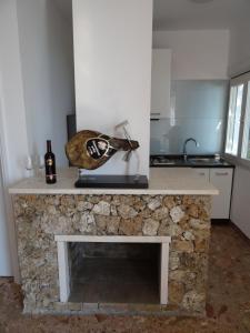 a stone fireplace in a kitchen with a bottle of wine at Holiday Home Waterfront Omis in Omiš