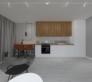 a kitchen with white cabinets and a table and chairs at Stylowe Apartamenty Plewiska in Plewiska