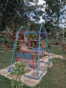 a blue and red swing set in a park at VILLA OPA DOEL YOGYAKARTA in Yogyakarta