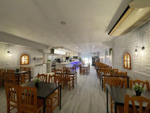 a restaurant with tables and chairs and a kitchen at Hostal Restaurante Avenida de Madrid in Terrassa