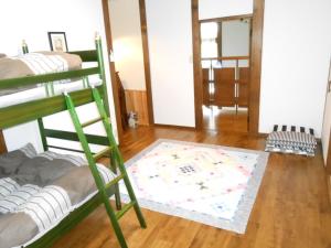 Villa Nugget Inn في أوماتشي: غرفة بسريرين بطابقين وسجادة