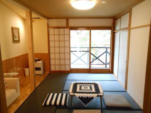 a living room with a table and a window at Villa Nugget Inn in Omachi