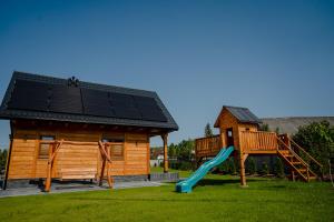 a playground with a house and a slide at Domki przy Alei in Krasnobród