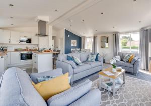 伯納姆馬基特的住宿－Oakrise，一间带蓝色沙发的客厅和一间厨房