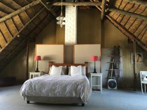 1 dormitorio con 1 cama con 2 lámparas y 2 mesas en Maylodge Country Cottages, en Hogsback