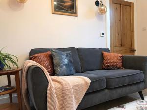 a couch with pillows on it in a living room at Newly renovated seaside townhouse with logburner in Nairn