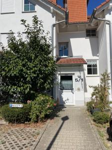 a white house with a white door and a tree at Ferienwohnung Kestel in Bad Bellingen