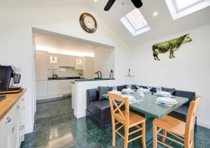 a kitchen and living room with a table and a cow on the wall at Pound Cottage in Holt