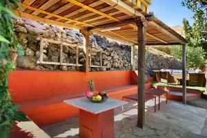 a patio with a wooden pergola and a table with fruit on it at Finca Rural Mar de Nubes in Vega de San Mateo