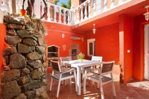 a dining room with a white table and chairs at Finca Rural Mar de Nubes in Vega de San Mateo
