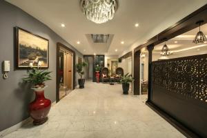 a hallway of a building with a vase on the floor at Hanoi Garden Hotel & Spa in Hanoi