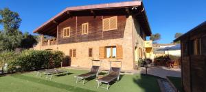 a house with chairs and a table in front of it at B&B La Baita Del Sud in Gonnesa