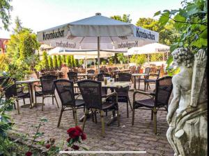 an outdoor restaurant with tables and chairs and umbrellas at Mansfelder Hof in Lutherstadt Eisleben