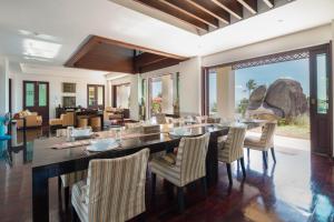 a dining room with a long table and chairs at Samui Ridgeway Villa - Private Retreat with Panoramic Sea Views in Koh Samui