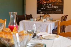 a table with a white table cloth on it with glasses at Les chambres de la vallée in Argenton-Château