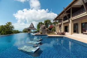 a swimming pool with chaise lounges on top of a building at Samui Ridgeway Villa - Private Retreat with Panoramic Sea Views in Koh Samui