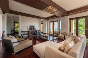a living room with white furniture and windows at Samui Ridgeway Villa - Private Retreat with Panoramic Sea Views in Koh Samui