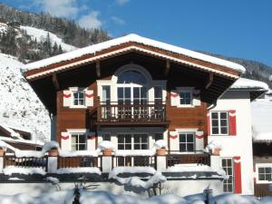 a house with a balcony in the snow at Apartments Blaickner in Neukirchen am Großvenediger