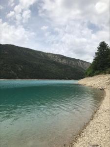 a large body of water with a rocky shore at Le gîte des Pins (meublé de tourisme 3 Étoiles) in Saint-Julien-du-Verdon