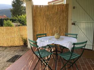 a table with chairs and a melon on it on a patio at Le gîte des Pins (meublé de tourisme 3 Étoiles) in Saint-Julien-du-Verdon