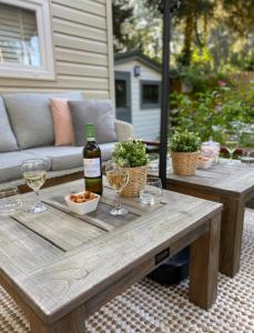 een houten tafel met een fles wijn en glazen bij Luxe Chalet met prachtig terras op de Veluwe , veel privacy in Hoenderloo