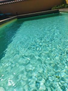 une grande piscine d'eau bleue dans l'établissement La ferme du vincent, à Liergues