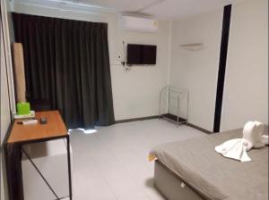 Schlafzimmer mit einem Bett, einem Tisch und einem TV in der Unterkunft P29 in Bangkok