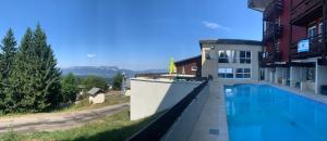 a large swimming pool in front of a building at Family apartment on the skiing slope in Allevard