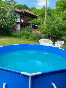 Yakovtsi的住宿－Вила Любима，蓝色的游泳池,带两把椅子和房子