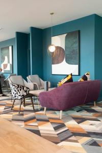 a living room with a purple couch and chairs at Crowne Plaza Birmingham NEC, an IHG Hotel in Bickenhill