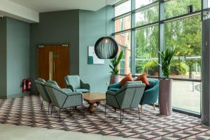 a lobby with chairs and a table and windows at Crowne Plaza Birmingham NEC, an IHG Hotel in Bickenhill