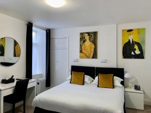 a bedroom with a white bed and a desk and a bed sidx sidx sidx sidx at Sarum Apart-Hotel in Saint Helier Jersey