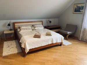 um quarto com uma cama grande e uma cadeira em Willa Na Wzgórzu em Masłów