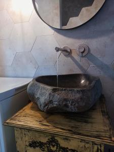 a stone sink sitting on a table with a mirror at The Dona House in Vaia