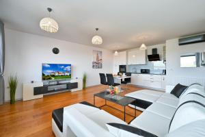 a living room with a white couch and a kitchen at Exclusive apartment in Varaždin in Varaždin