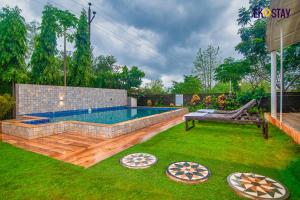 a backyard with a swimming pool and a bench at EKOSTAY - Cozy Nest Villa in Karjat