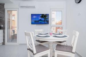 a white dining room with a white table and chairs at Espanatour SAN PASCUAL 216 in Torrevieja