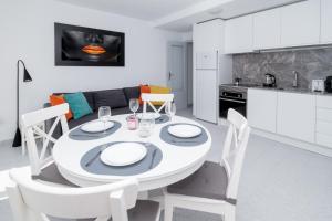 a white kitchen and dining room with a white table and chairs at Espanatour SAN PASCUAL 216 in Torrevieja