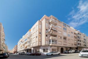 a tall building with cars parked in front of it at Espanatour SAN PASCUAL 216 in Torrevieja