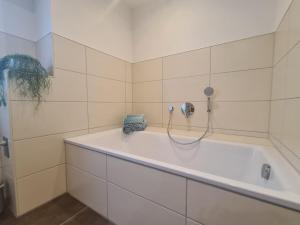 a white bathroom with a tub and a telephone at Ferienwohnung Zilliken in Treis-Karden