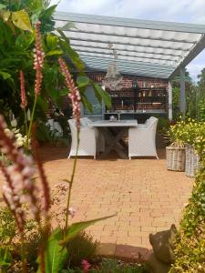 eine Terrasse mit einem Tisch und Stühlen im Garten in der Unterkunft Luana`s White Cottage in Surwold