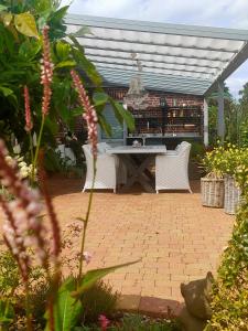 a patio with a table and chairs in a garden at Luana`s White Cottage in Surwold